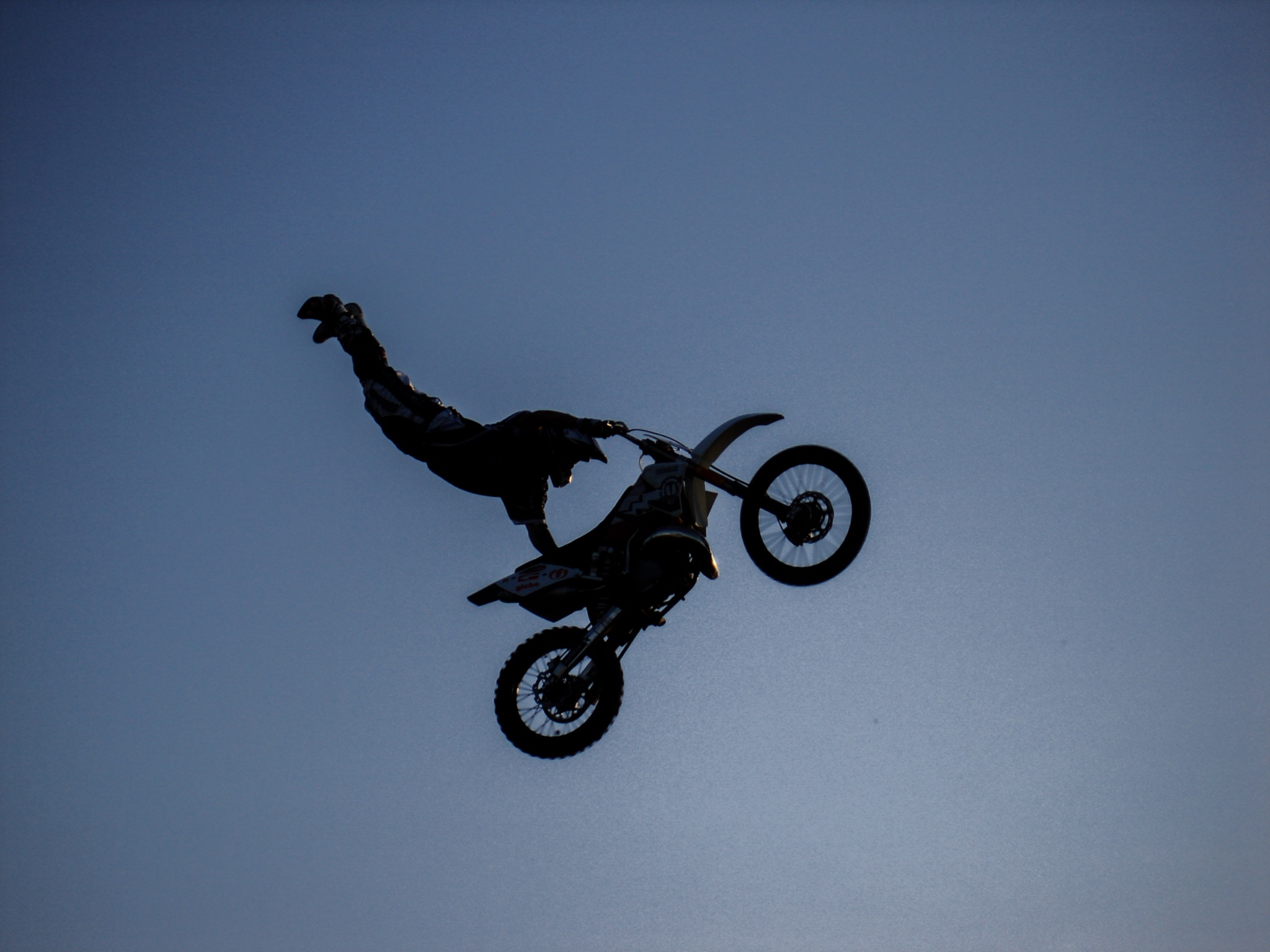 Motocrossfahrer bei einem Sprung vor blauem Himmel